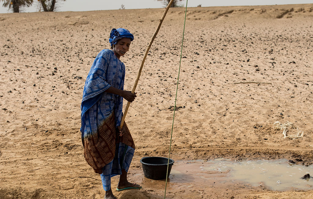 Binta takes water from a well