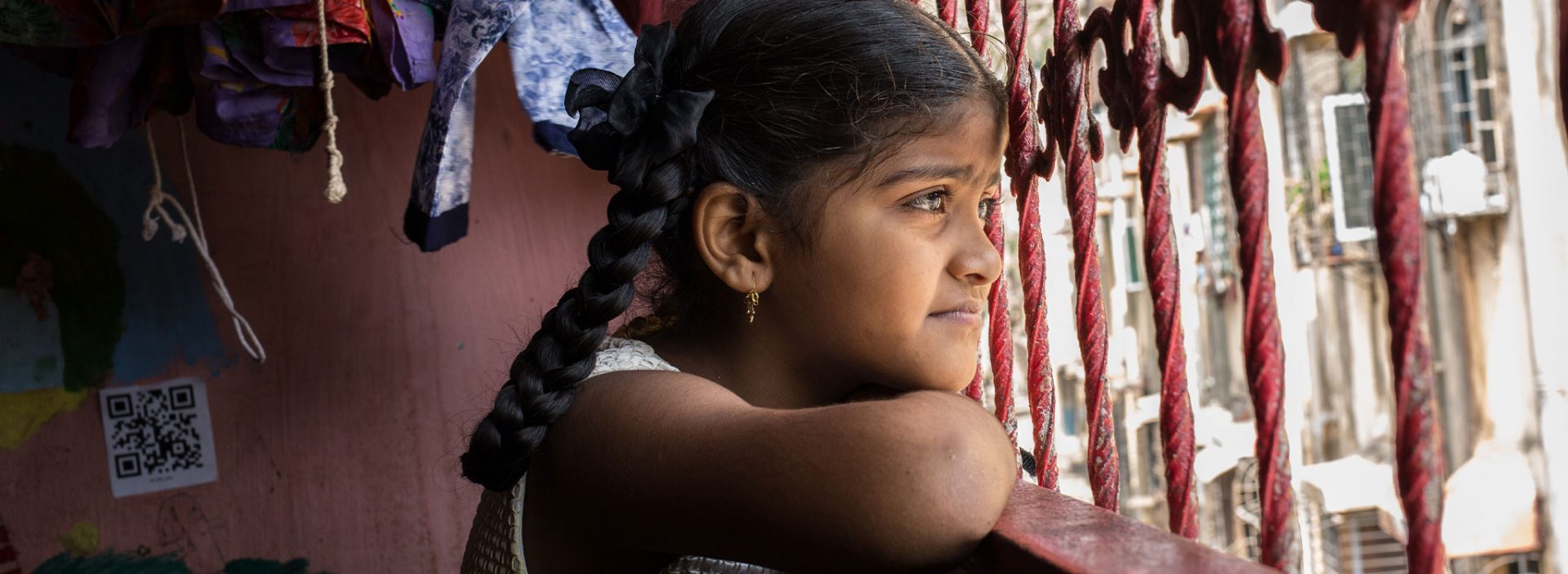 A young girl looks out of the window in India