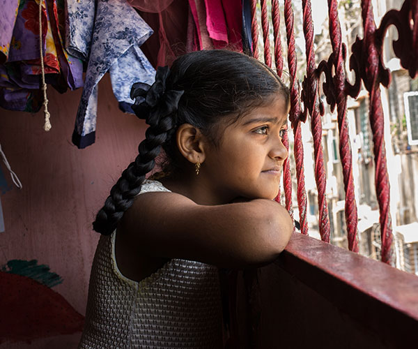 A young girl looks out of the window in India