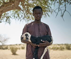 A man holds a goat at an Action Against Hunger project in Chad.