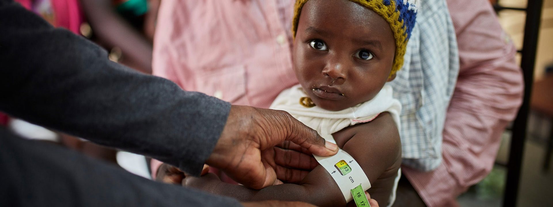A child is screened for malnutrition using a MUAC band at an Action Against Hunger treatment centre in Haiti.