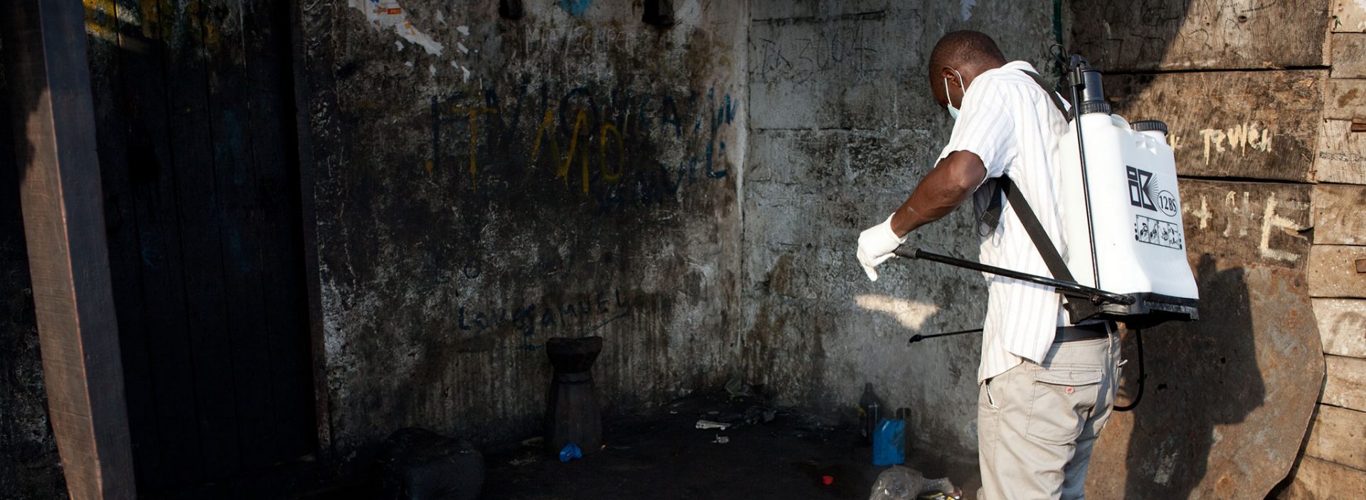 An Action Against Hunger member of staff sanitises an building in Liberia.