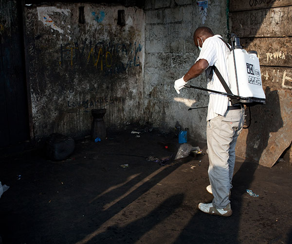 An Action Against Hunger staff member sanitises an area in Liberia.