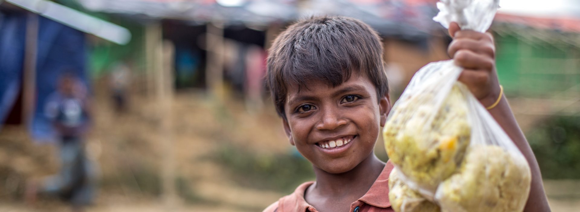 Muk collects a bag of rice at an Action Against Hunger distribution centre in Bangladesh.