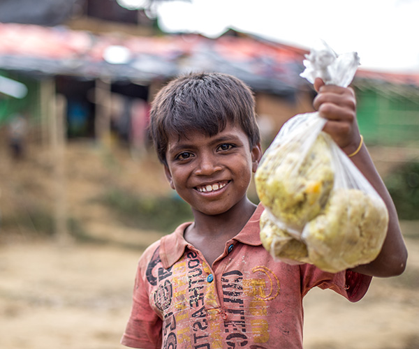 Muk collects bag of rice at an Action Against Hunger distribution centre in Bangladesh.