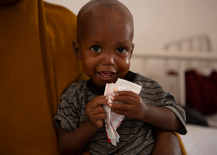 Mohamed eats ready-to-use therapeutic food at an Action Against Hunger stabilisation centre in Mogadishu, Somalia.