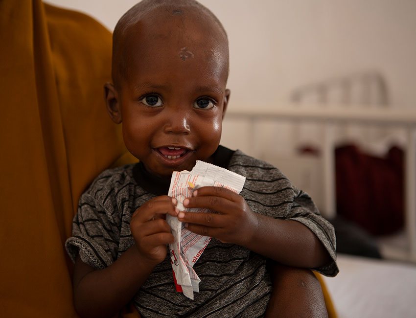 Mohamed eats ready-to-use therapeutic food at an Action Against Hunger stabilisation centre in Mogadishu, Somalia.