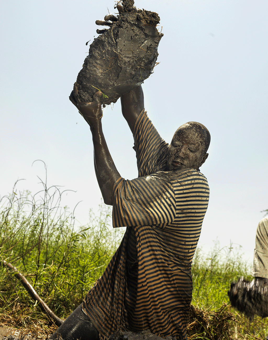 Stephen Riek, 44, helps to build a dike to save Pankiir Village. South Sudan 