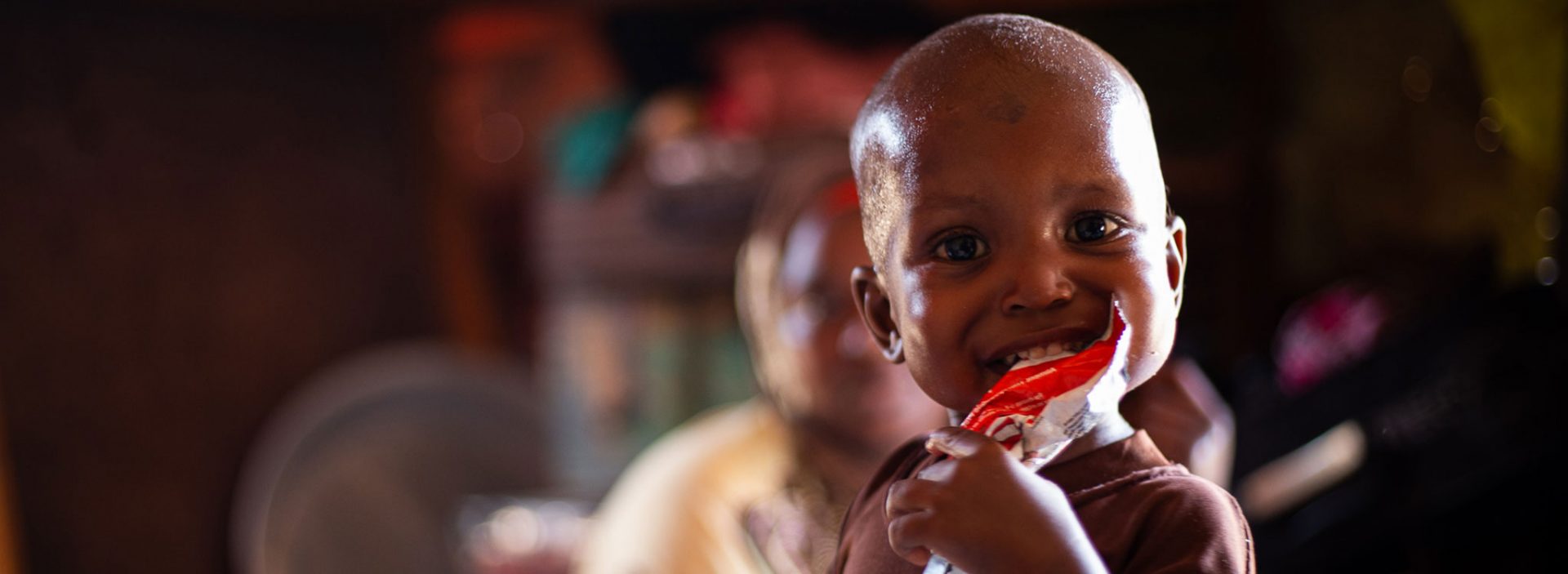 Mohamed from Mogadishu, Somalia, eats ready-to-use therapeutic food at home after receiving treatment for malnutrition from Action Against Hunger.