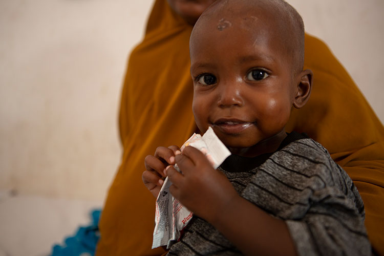 Mohamed eats ready-to-use therapeutic food at an Action Against Hunger stabilisation centre in Mogadishu, Somalia.