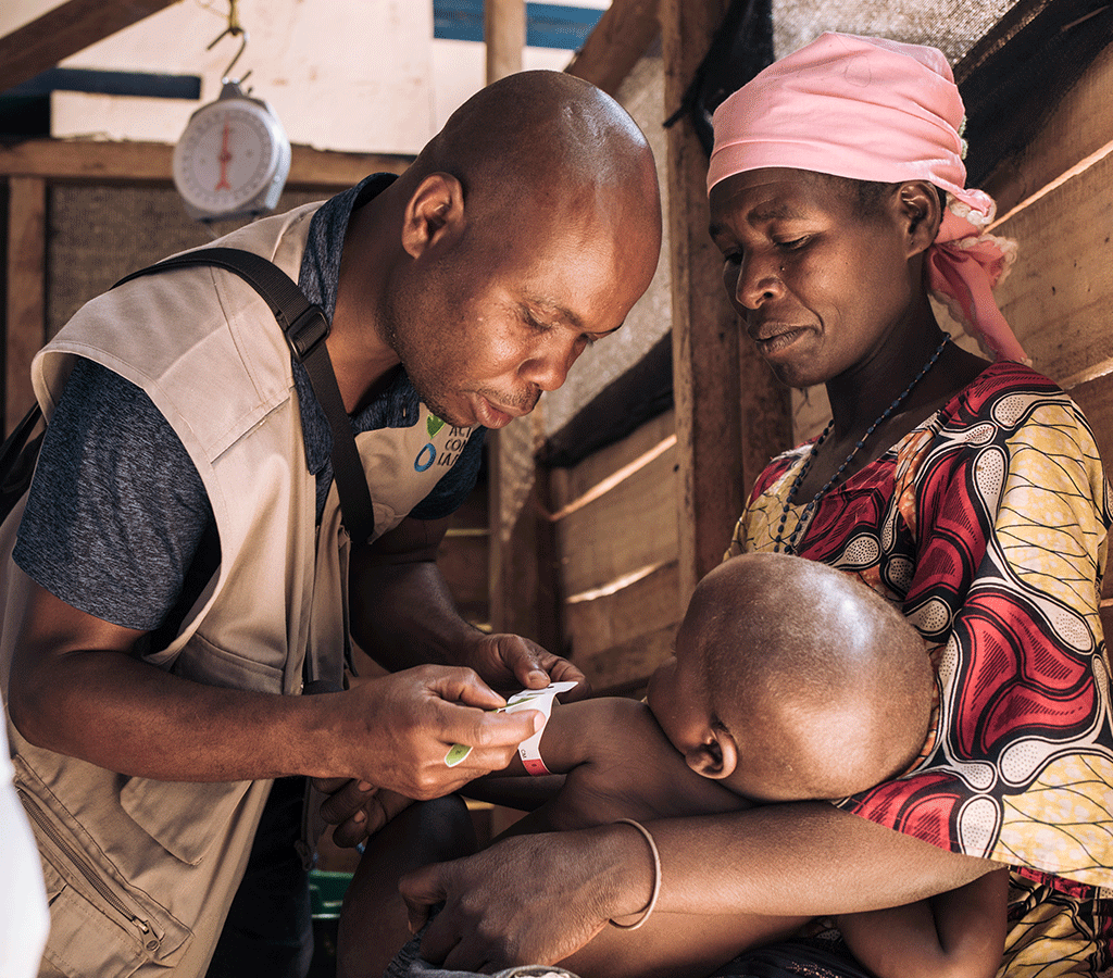 Clovis Fikirirni, assistant to the head of ACF Nutrition / Health programs, checks the MUAC of David Wauba, 27 months old, suffering from severe acute malnutrition in the DRC