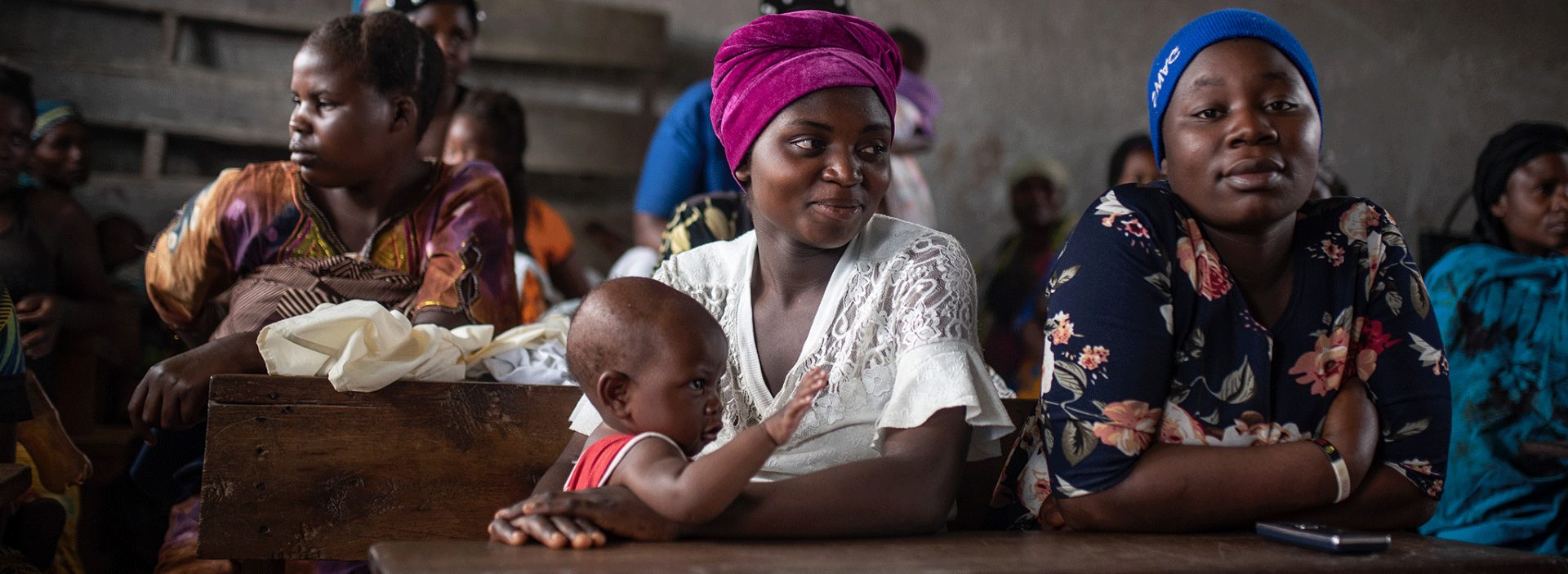 Esther Bunyere with her 8 month old daughter and Micheline Shukur, during a mental health session at a school in Kichanga.