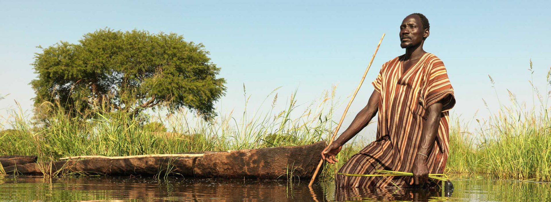 Gai tries to spear fish after his village in South Sudan is flooded.