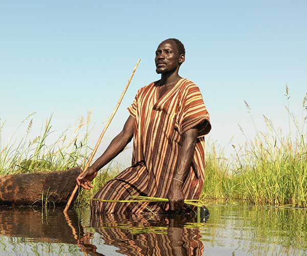 Gai tries to spear fish after his village in South Sudan is flooded.