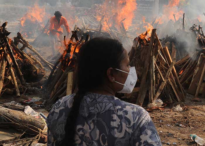 A family member looks on at funeral pyres of victims of coronavirus in India.