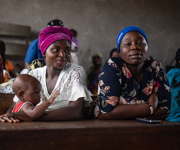 Esther with her eight-month-old daughter and Micheline during a mental health session at a school in Kichanga, DR Congo.