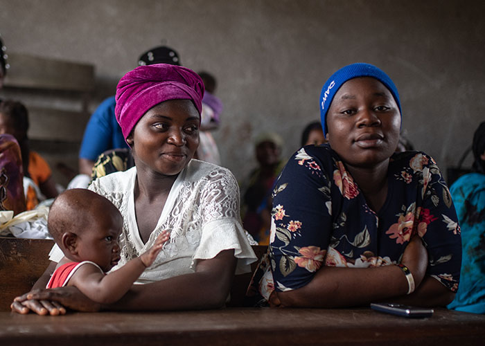 Esther with her eight-month-old daughter and Micheline during a mental health session at a school in Kichanga, DR Congo.