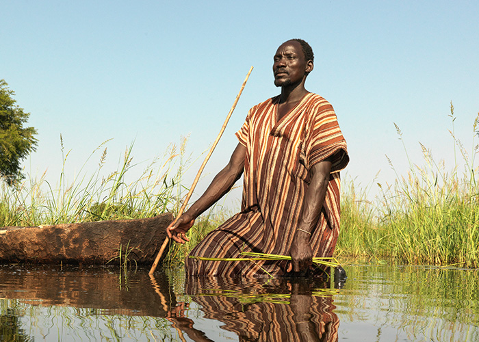 Gai tries to spear fish after his village in South Sudan is flooded.