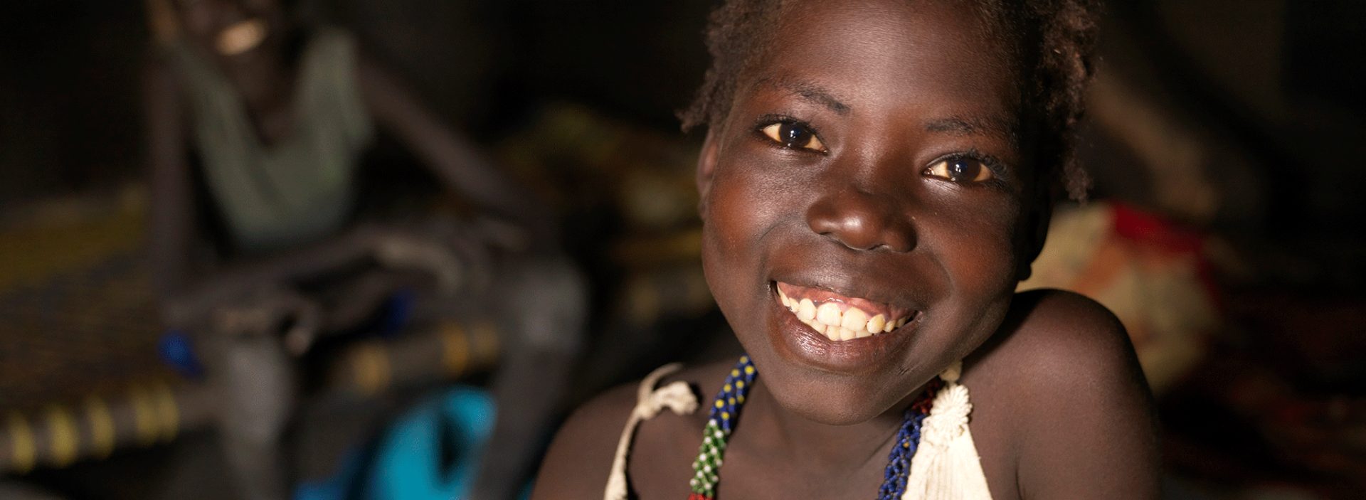 A smiling girl who's been supported by Action Against Hunger.