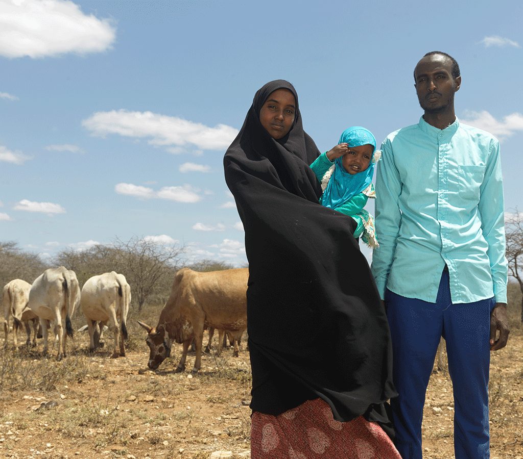 Medina Munira and Isac stand with their livestock in Ethiopia.