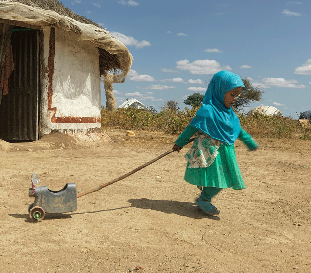 After recovering from malnutrition,Munira plays with her toy outside her house in Ethiopia 