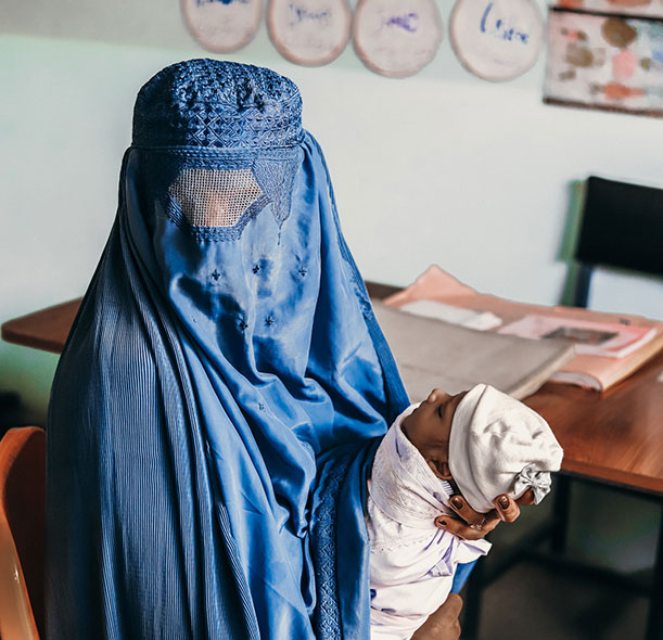 A woman in Afghanistan holds her baby.