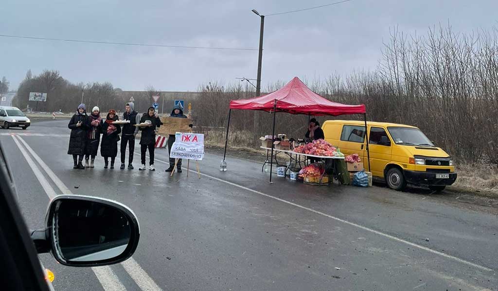 Food being handed out at a checkpoint in Ukraine. The sign says "Tea, coffee, free of charge."