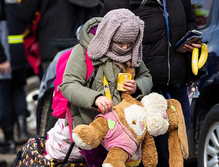 A girl holding a rabbit who's fleeing Ukraine.