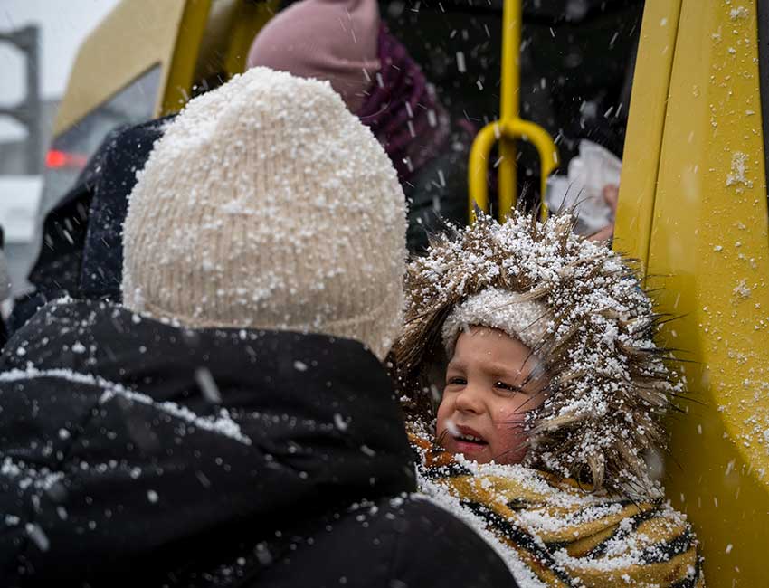 A family wait to board a bus in Palanca, Moldova.