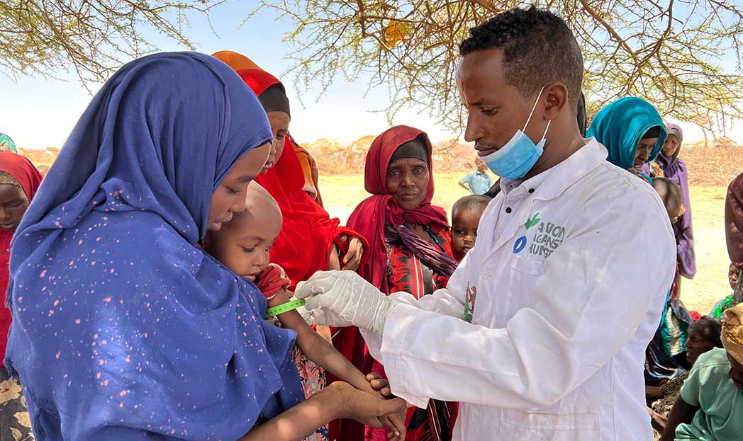 A member of Action Against Hunger's mobile teams screens a child for malnutrition in Somalia.