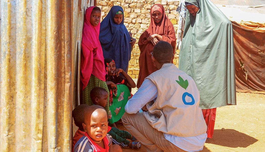 An Action Against Hunger staff member helps those forced to leave their homes at a makeshift camp in Somalia.