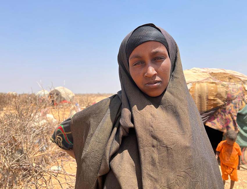 A photo of Mumina, a woman who walked 10 miles with her three children to find food and water.