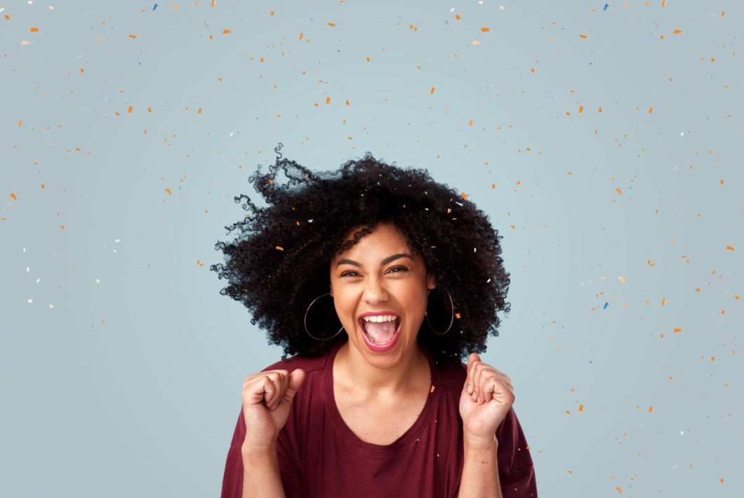 Lady with frizzy hair celebrates winning the Action Against Hunger weekly lottery