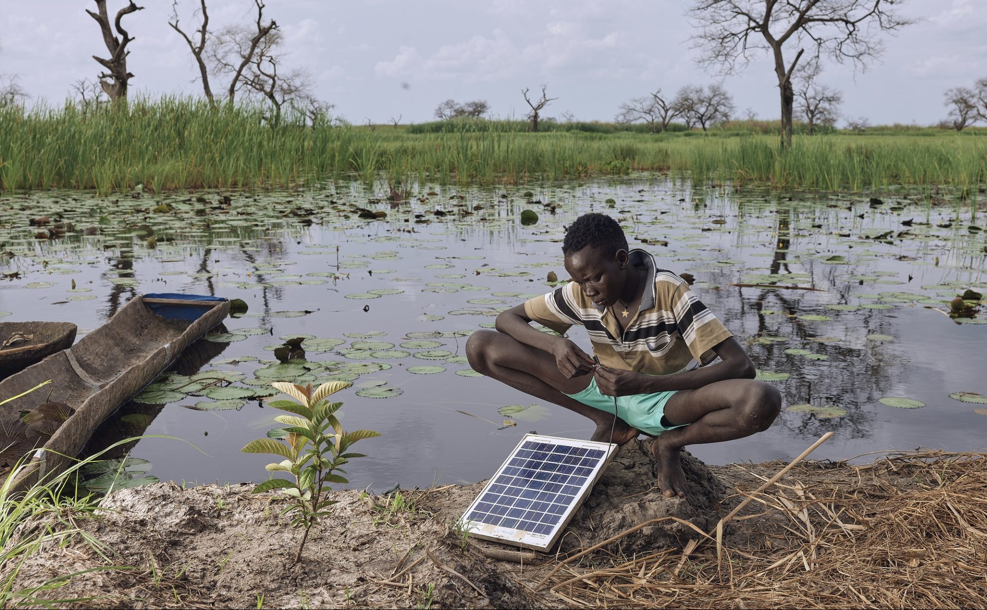 Gatwal Nhial, 9, repairs a solar panel which is their only source of power on his floating grass island in what used to be Wangkotha Village