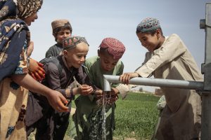 Children plays with water in a pump installed a few days ago.