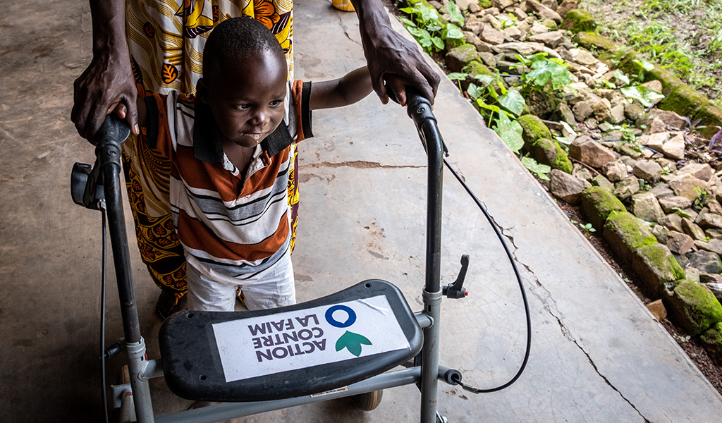 Dieubéni uses a mobility aid to walk.