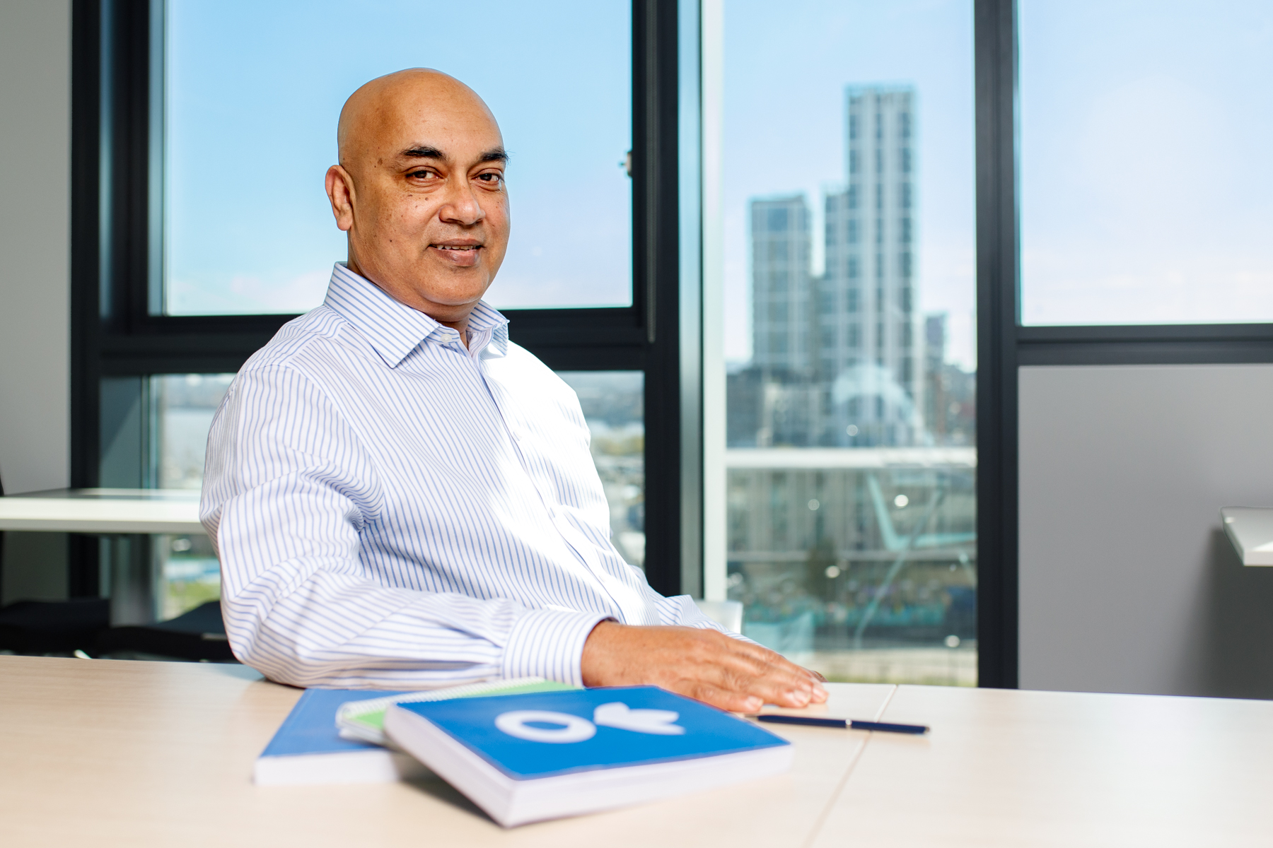 Director of Finance, IT and Administration, Jamal Uddin, sitting at a desk