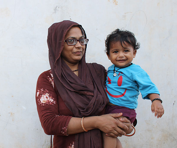 A mother with her smiling child supported by Project Vruddhi in India.