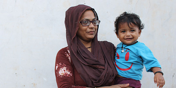 A mother with her smiling child supported by Project Vruddhi in India.