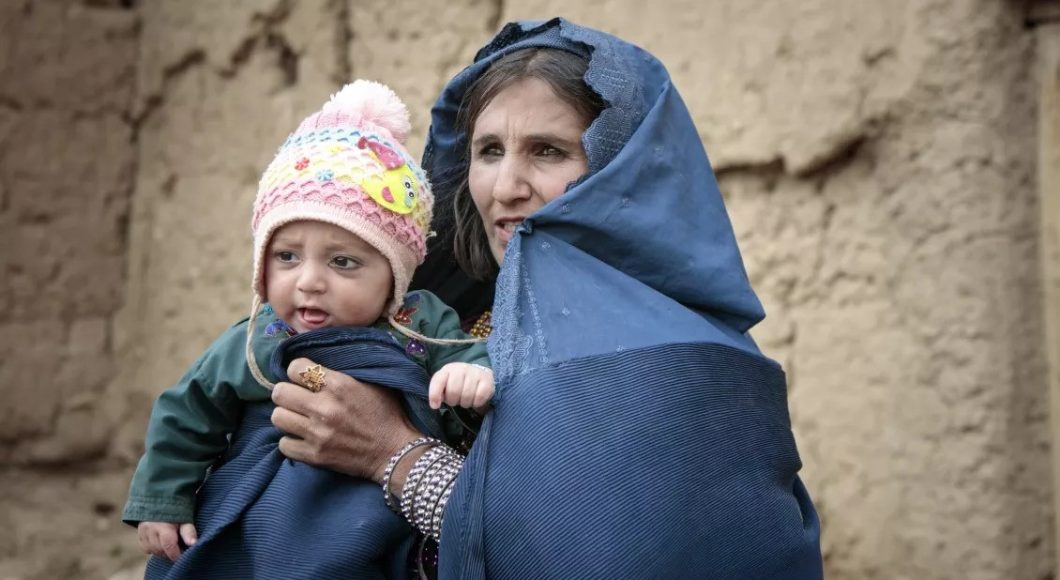 A mother holds her malnourished child, who is receiving treatment from Action Against Hunger.