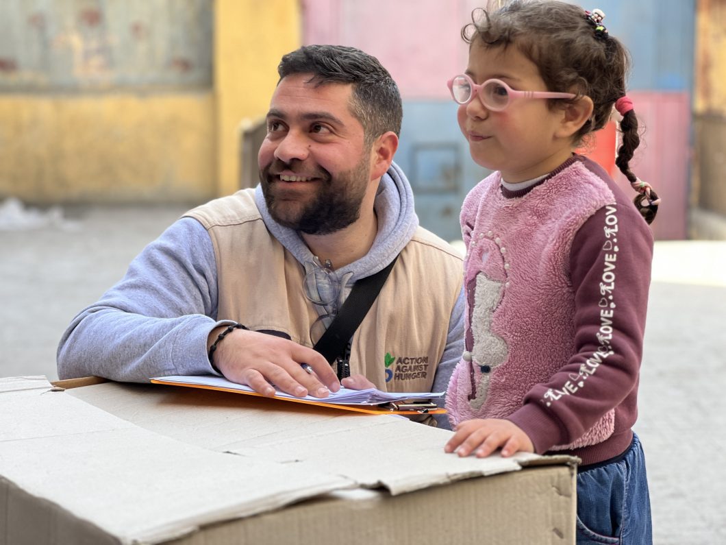 Bassel, head of Action Against Hunger's Monitoring and Evaluation team in Aleppo, with one of the earthquake victims who received winterization kits © Action Against Hunger.