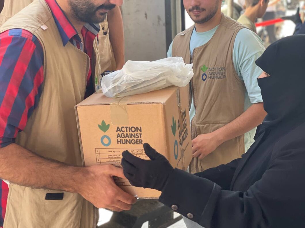 A woman being given a food package by an aid worker