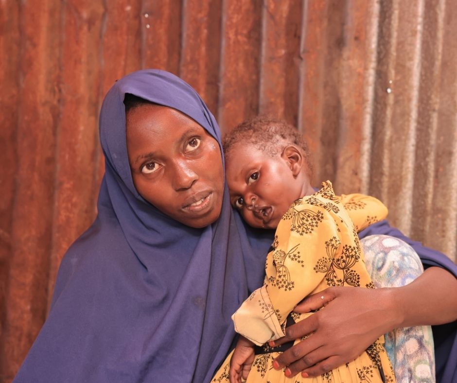 A portrait of a mother in Somalia holding her child.