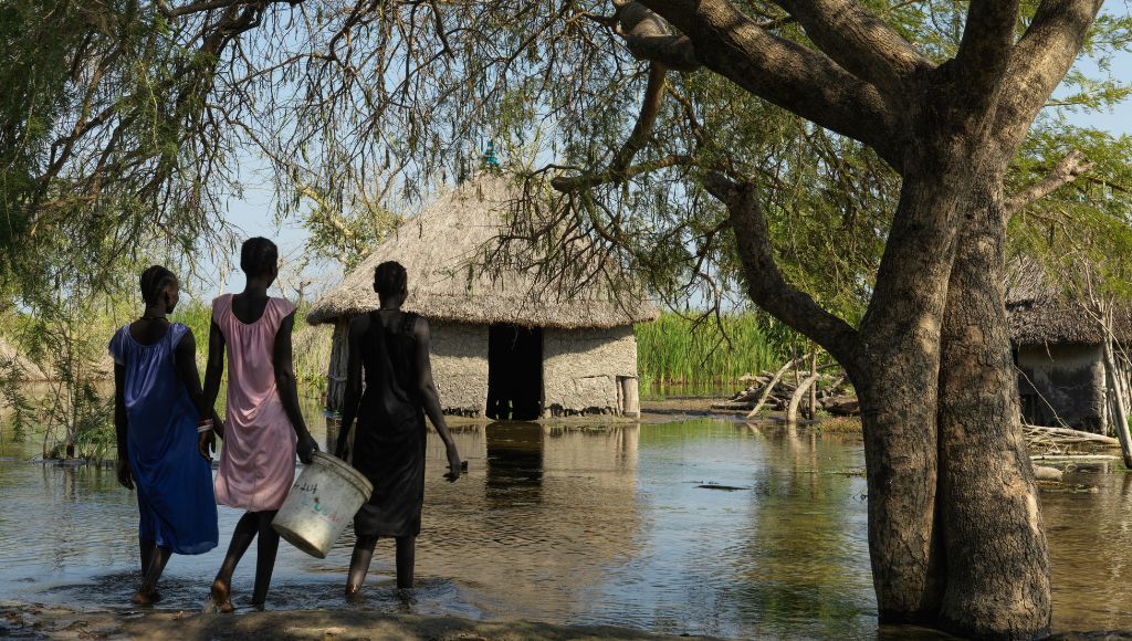 Women walk in flooded village in South Sudan.