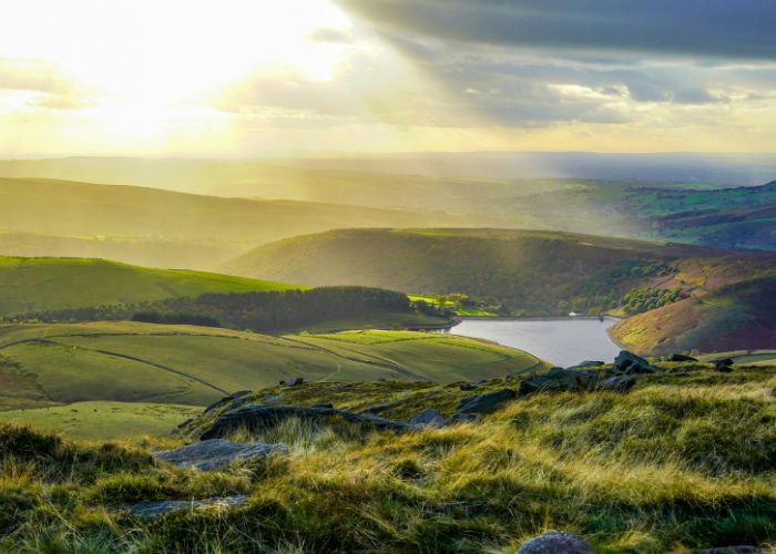 Rolling hills in Peak District with dappled sunlight.